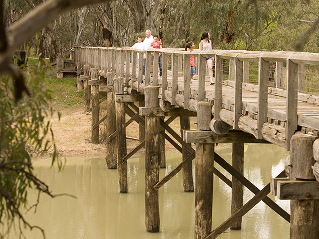 people crossing the Murray river on a wooden bridge